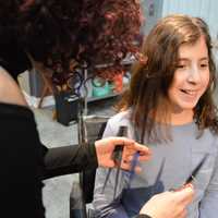 <p>Industrie Stylist Denise Santero of Hawthorne cuts a long blue hair extension to match the length of 10-year-old Olivia Vigliotti&#x27;s hair.</p>