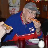 <p>A member of The Spartans bites into a slice of cheese pizza at Patsy&#x27;s Tavern and Restaurant in Paterson.</p>