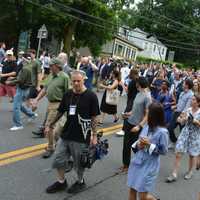 <p>A large press scrum, along with Hillary Clinton&#x27;s entourage, head down the King Street hill in downtown Chappaqua as part of the Memorial Day parade route.</p>