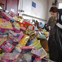 <p>A volunteer prepares gifts for loading.</p>