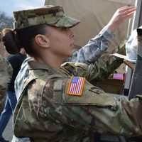 <p>A military member from the Teaneck Armory loads a gift onto a truck.</p>