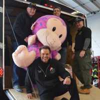 <p>Don Nicoletti, bottom, and PBA members load a giant stuffed monkey into the Paramus Motorcycle Unit trailer.</p>