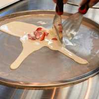 <p>Step one: creating a strawberries and cream treat at Rolling Cow.</p>