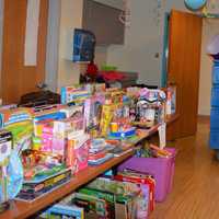 <p>Bergen County Police Officers bring gifts into an already-packed room.</p>