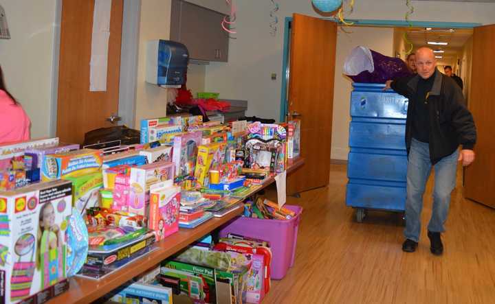 Bergen County Police Officers bring gifts into an already-packed room.