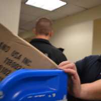 <p>Englewood Cliffs Police Officer Marc Krapels pushes a bin full of toys through the HUMC halls.</p>