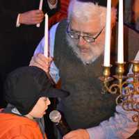 <p>Rabbi Yehoshua Hecht encourages a young participant to sing during a menorah lighting ceremony Stew Leonard&#x27;s in Norwalk Monday.</p>