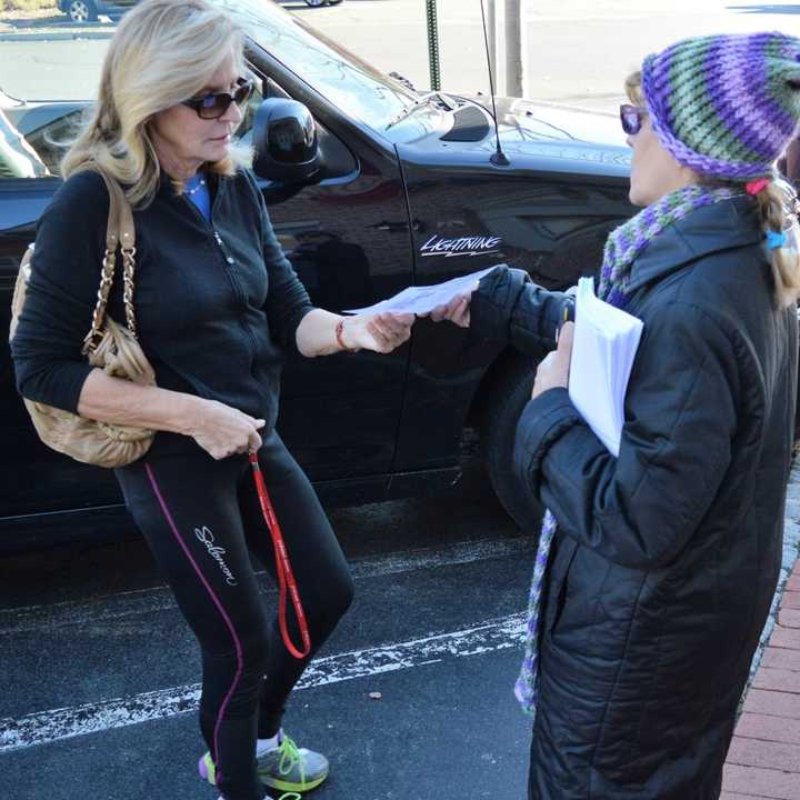 Doreen Frega of Saddle Brook gives a Saddle River shopper a flier on the dangers of bow hunting deer in the borough.