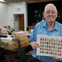 <p>A collector shows off some of his prized stamps at Saturday&#x27;s show.</p>