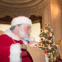 <p>Santa Claus writes children’s wishes down at the Lockwood-Mathews Mansion’s Holiday Open House</p>