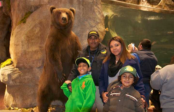 A family poses with a bear at the new Bass Pro Shop at the grand opening in Bridgeport on Wednesday.