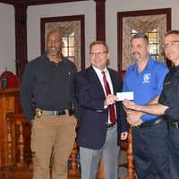 <p>Stratford Mayor John Harkins, second from left, donates $10,000 from his charity golf tournament to Stratford PAL as (left to right) Lt. Curtis Eller, School Resource Officer Alex Voccola and Police Chief Joseph McNeil look on.</p>