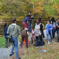 <p>Beardsley Zoo educator Gian Morresi helps students release brook trout into the Pequonnock River in Beardsley Park.</p>