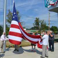 <p>Bottle King owner Kenneth Friedman and members of the American Legion and VFW raising the flag</p>