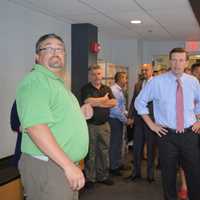 <p>Unit Director Jason Macchia, left, leads U.S. Sen. Chris Murphy, center, and others on a tour of the Smilow-Burroughs Clubhouse in Bridgeport.</p>