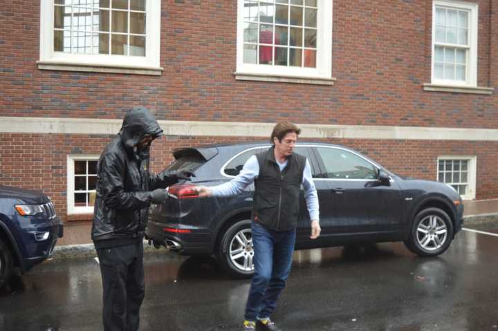 A shopper hands his keys off to a rain-soaked valet outside the new Bedford Square development in downtown Westport.