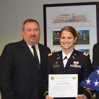 <p>Mahwah Council President Robert Hermansen, Danielle Ullman and Mayor Bill Laforet pose with a flag that flew over Afghanistan, where Ullman served with the U.S. Army.</p>