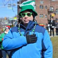 <p>A parade-goer with a hand over his heart as he pledges allegiance to the American flag at a ceremony at the Roy E. Brown Middle School.</p>