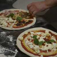 <p>A chef prepares Margherita pizza (right), and the restaurant&#x27;s popular &#x27;Four Season&#x27; Pizza - with mushrooms, olives, mozzerella and artichokes.</p>