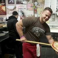 <p>Napoli&#x27;s Doug Conway pulls a pie from the oven.</p>