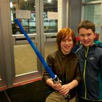 <p>A boy holds a light saber as he and a buddy head in to see &quot;Star Wars: The Force Awakens&quot; on Thursday evening in Stamford.</p>