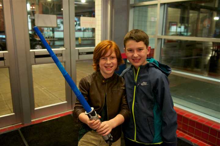 A boy holds a light saber as he and a buddy head in to see &quot;Star Wars: The Force Awakens&quot; on Thursday evening in Stamford.