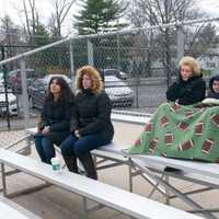 <p>Fans try to stay warm on a cold day at New Rochelle High School.</p>