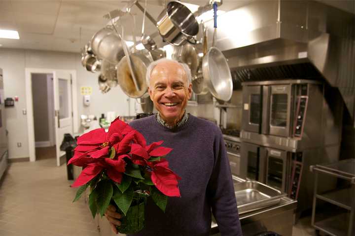 Bob Mitchell gets poinsettias in place as the final touch for the church&#x27;s Christmas day community luncheon.