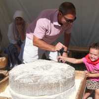 <p>Pushing a hand-powered grist mill at Cornucopia.</p>