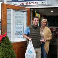 <p>Happy customers leave Rowayton Seafood on Christmas Eve with fixings for a feast.</p>