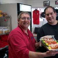 <p>Rowayton Seafood manager Scott Bennett hands over a shrimp platter to a happy customer on Christmas Eve.</p>