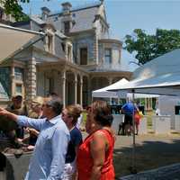 <p>Visitors view artwork at the Norwalk Art Festival on Sunday in the shadow of the Lockwood-Mathews Mansion.</p>