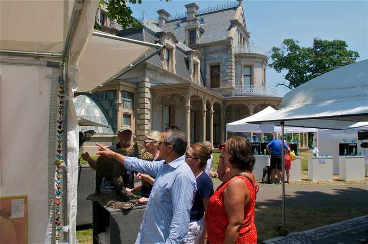 Visitors view artwork at the Norwalk Art Festival on Sunday in the shadow of the Lockwood-Mathews Mansion.