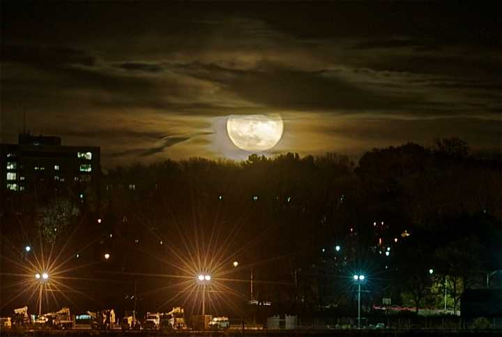 A supermoon peeks through the clouds.&nbsp;