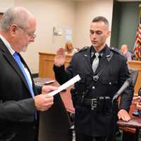 <p>Hillsdale Mayor Douglas Frank swears in Patrolman Corey Rooney as his mother, Patti Rooney, looks on, and his father, Rick Rooney, holds the Bible.</p>