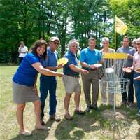 <p>Officials, including Senator Sue Serino (far L) and County Executive Marcus Molinaro (4th from left) celebrate the grand opening of the Wilcox Memorial Park Disc Golf Course.</p>