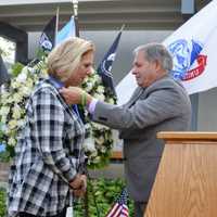 <p>Bergen County Executive James J. Tedesco III presents a military service medal to Stefanie Ulrich on behalf of her father, the late Murray Kent Ulrich, a World War II veteran and German POW.</p>