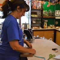 <p>Donna Kattowski, left, wraps a chocolate assortment with a bow for a customer.</p>