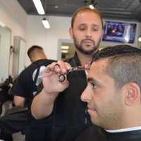 <p>The Shave Bar &amp; Barbershop owner Evan Vidal cuts Ali Poury&#x27;s hair in the Broadway shop.</p>