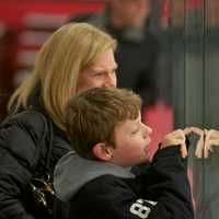 <p>Spectators watch the game through the glass Friday at the Brewster Ice Arena.</p>