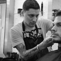 <p>Stephen Bogosian works on a regular client Thursday at the shop.</p>