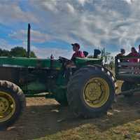 <p>Visitors take a hay ride at Outhouse Orchards.</p>