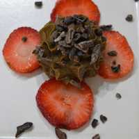 <p>Raw vegan chocolate mousse with strawberry slices and chocolate pieces.</p>