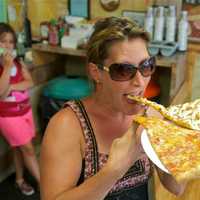 <p>A happy customer enjoying a few slices at Cacciatori Pizza.</p>