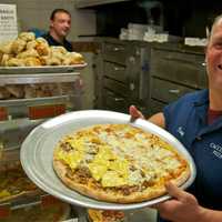 <p>Manager Patsy Femia with one of Cacciatori&#x27;s made-to-order pies.</p>