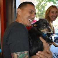 <p>Guerrilla Fitness owner Joe Ghaznavi and Robyn Hendrix play with an adoptable dog.</p>