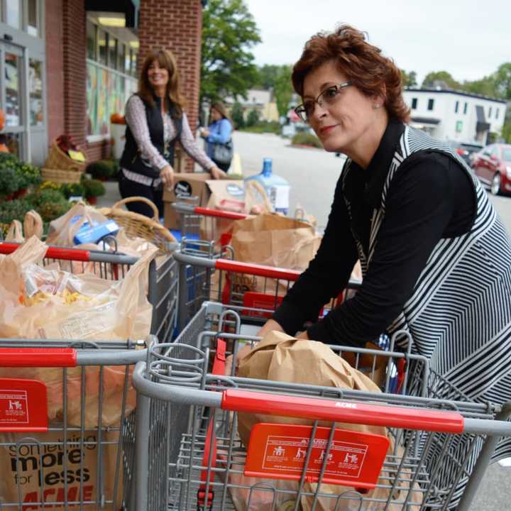 Prominent Properties Real Estate Agents Juliette Gorham, foreground, and Sophia Meneve organize donated groceries outside the Allendale ACME.