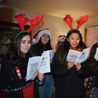 <p>Carolers sing &quot;We Wish You A Merry Christmas&quot; and other holiday favorites in DeFontes&#x27; living room.</p>