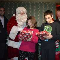 <p>Melissa and Matthew unwrap new iPads from Santa Boone -- Ex-Detective David Boone. Mayor John Cosgrove looks on from behind.</p>