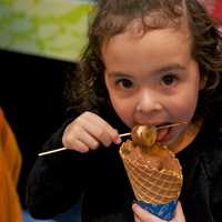 <p>A young girl enjoys a chocolate treat at the Chocolate Expo at the Maritime Aquarium at Norwalk on Sunday.</p>